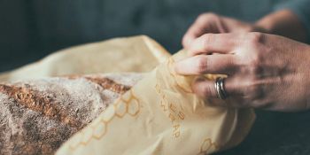 Un beeswrap est utilisé pour couvrir un pain à la place d'un fillm plastique étirable