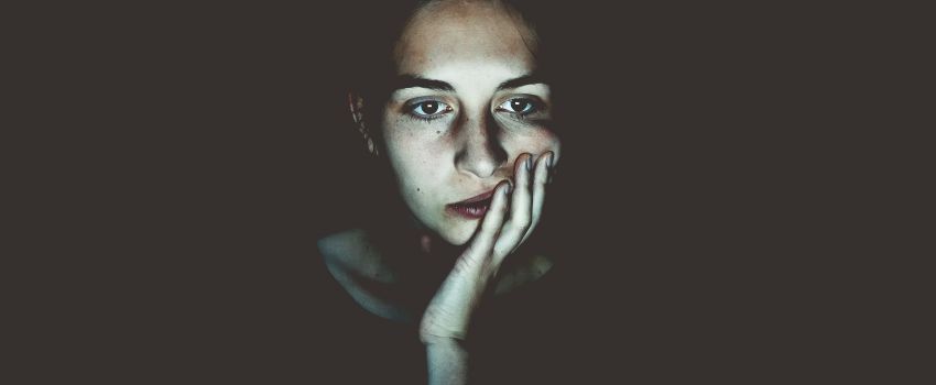 Femme perplexe sur un fond sombre